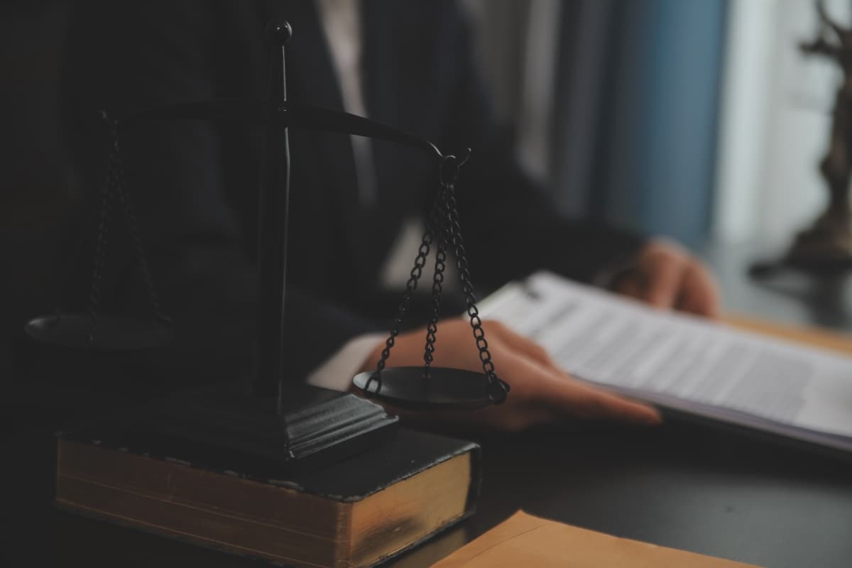 Scales of justice on a law book on the desk of the law firm Lutz Färber