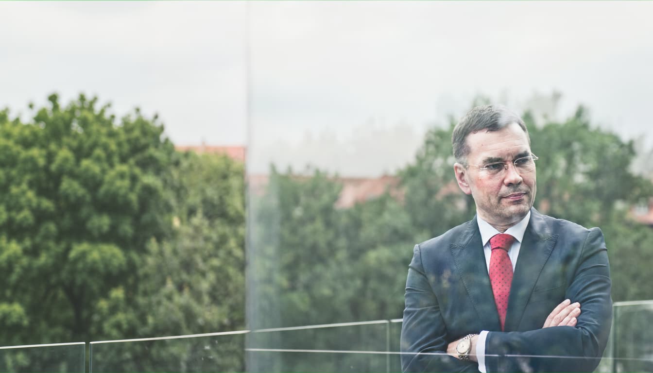 Portrait of attorney Lutz Färber, pensive in front of a glass façade
